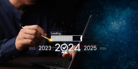 Countdown to 2024 concept. the taps a virtual download bar with a loading progress meter on New Year's Eve, turning the year 2023 to 2024.
