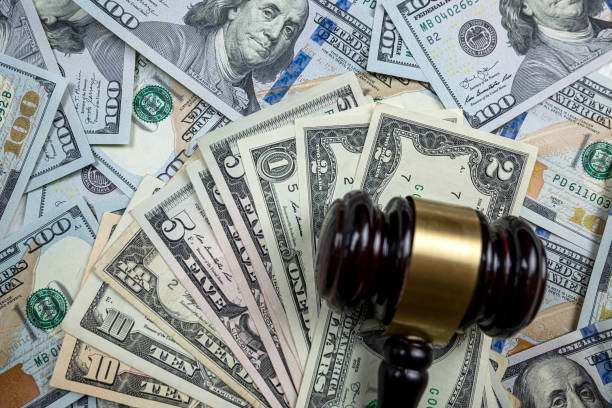 istock wooden hammer on one hundred dollar bill 1530379836
