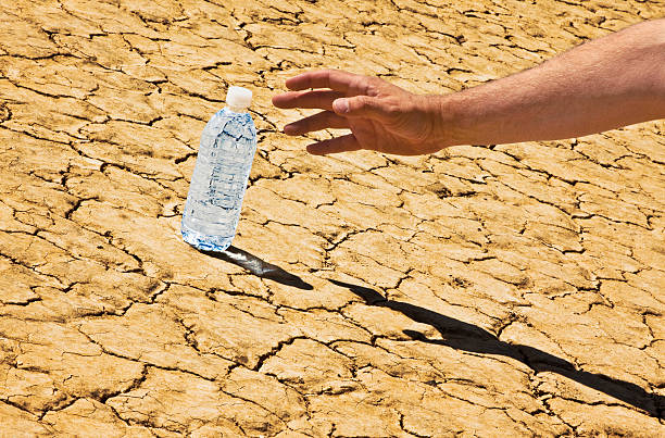 Atteindre pour bouteilles d'eau dans le désert Tilted - Photo