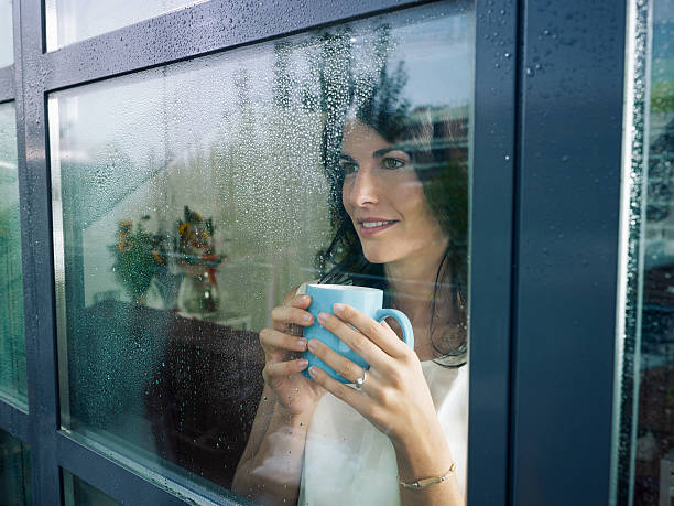 istock woman staring at the window 153038780