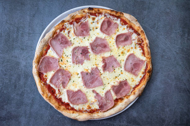 istock Homemade ham and cheese pizza on a rustic background. top view 1530397310