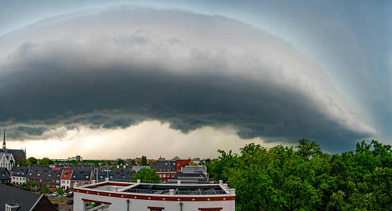 Storm clouds over Zwolle during a summer thunderstrom at the end of a warm and humid summer afternoon. A shelf cloud is approaching over the rooftops.