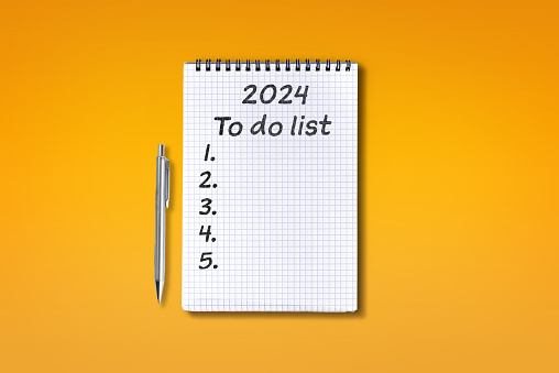 2024 To do list lettering on squared notebook, isolated on orange background