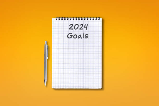 istock 2024 Goals lettering on checkered notebook, isolated on orange background 1530416602