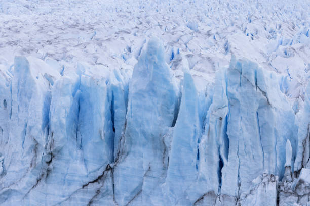 Perito Moreno glacier in Patagonia, Argentina. Blue ice glacier with huge seracs falling into the waters of a glacier lake. Ice shining on the sun with deep blue color in the cold Antarctic region of South America