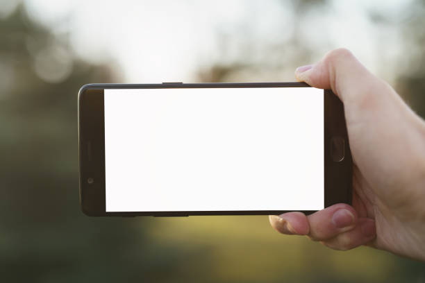 istock man right hand holding smartphone with white screen outdoors with spring blurred background 1530428260