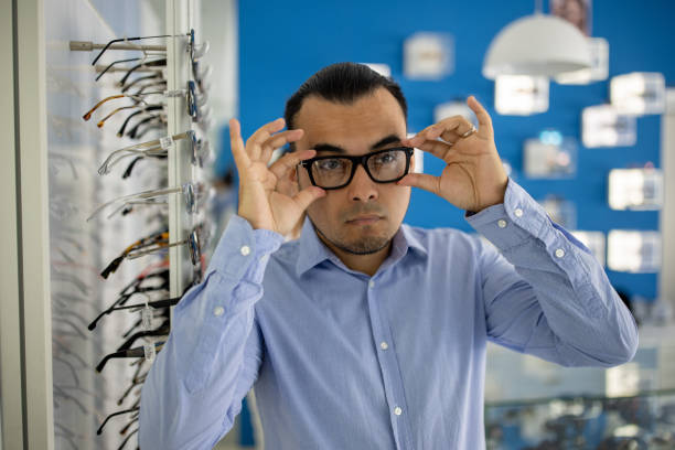 istock Man choosing a pair of glasses in a store 1530437259