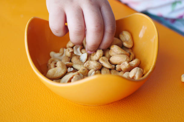 istock child hand pick peanuts in a bowl on table 1530437718