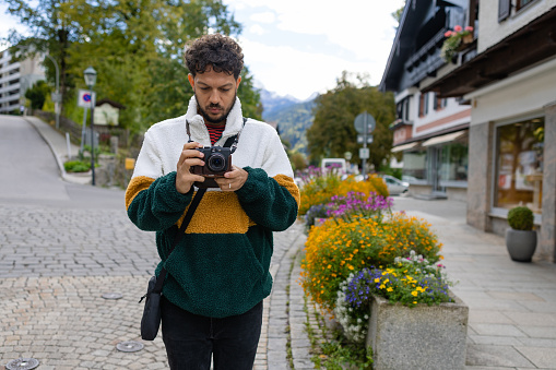 A point of view front view of a man wearing a fleece top taking a picture of his partner as they enjoy a trip to Garmisch in southern Germany. They are travelling and enjoying some time away travelling together.