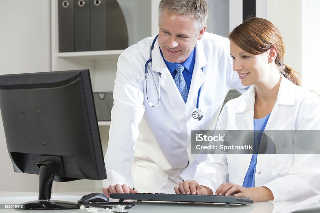 Male Female Hospital Doctors Using Computer Male & female medical doctors using computer in a hospital office 30-39 Years Stock Photo