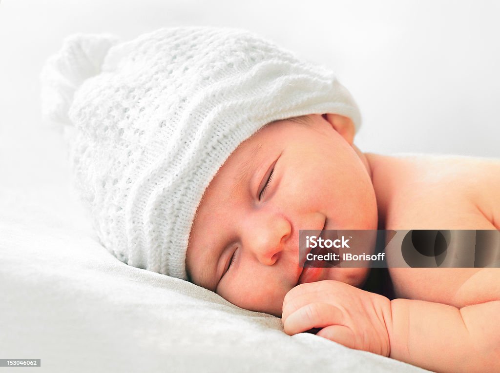 smiling newborn baby in white hat smiling european newborn baby in white hat Sleeping Stock Photo