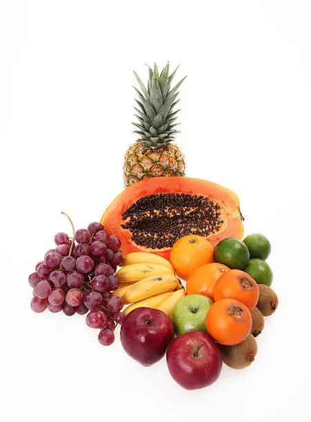 delicious fruits like pineapple, banana, grape, lemon, apple, papaya over white background