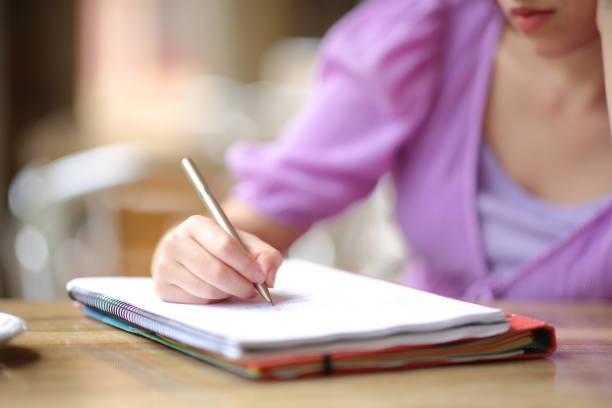 istock Close up of a student writing notes in a terrace 1530488505