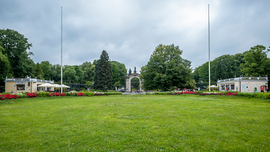 Chorzow, Poland - June 29, 2023: The monumental main gate to the zoo. Beautiful lawn in the foreground