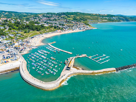 Boats in Lyme Regis Harbour with beach behind