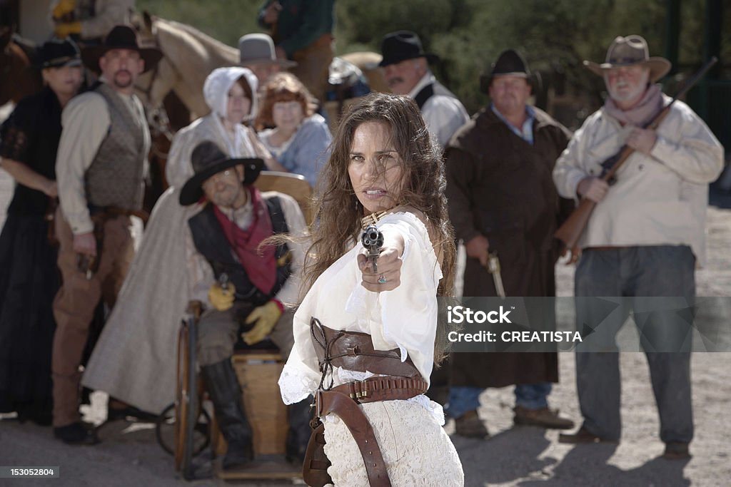 Un po'provocatorio cowgirl Pistola puntamento. - Foto stock royalty-free di Arma da fuoco