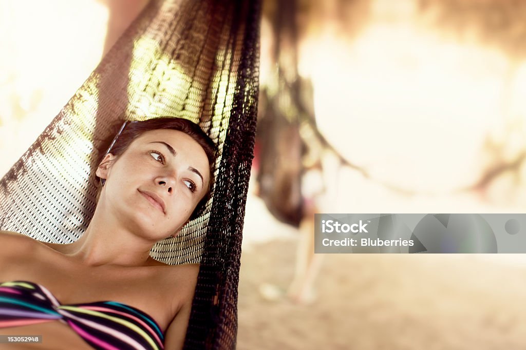 Beach Vacation Young woman relaxing in a hammock. Adult Stock Photo