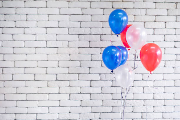istock Bright colorful balloons against white brick wall background. 1530541312