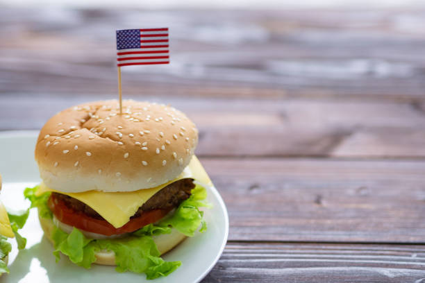 istock Hamburger on wooden table with American flag pin 1530544783
