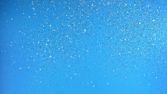 SLO MO LD Blue glitter falling against blue background