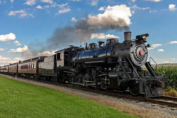 historic steam train passes through the fields