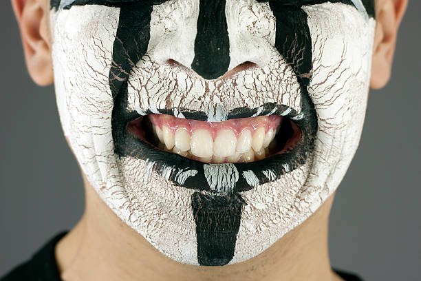 istock Cracked white paint on young man face 153055615