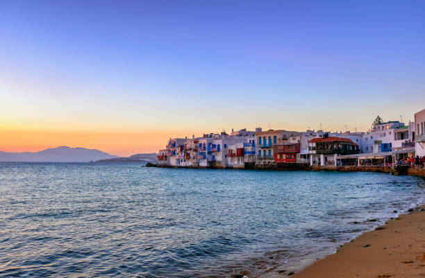 bela vista do pôr do sol de little venice, mykonos, grécia. bairro romântico com bares, cafés, restaurantes em antigas casas de pescadores acima das ondas do mar - scenics multi colored greece blue - fotografias e filmes do acervo