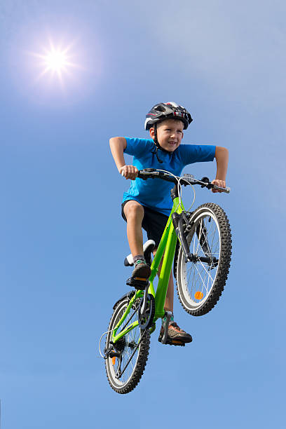 young boy salto en una bicicleta bajo el sol - bmx cycling cycling bicycle teenager fotografías e imágenes de stock