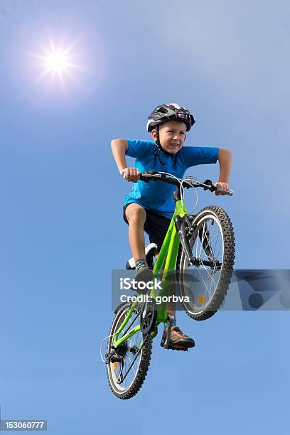 Giovane Ragazzo Saltare Su Una Bicicletta Sotto Il Sole - Fotografie stock e altre immagini di Bambino