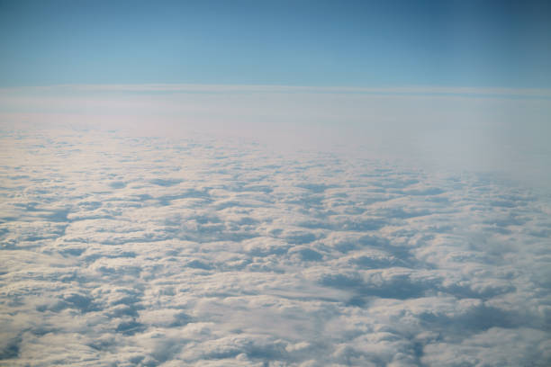 istock aerial shot from plane flying above the clouds in daytime 1530615054
