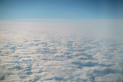aerial shot from plane flying above the clouds in daytime, plane travel