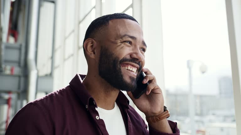 Laughing, talking and a man on a phone call at work for business, networking and communication. Happy, office and a thinking employee speaking about an idea on mobile for a telephone discussion