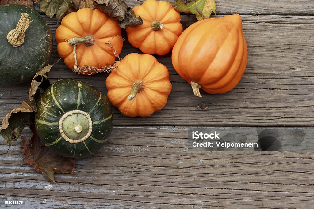 Autumn pumpkins Autumn pumpkins with leaves  on wooden board Acorn Squash Stock Photo