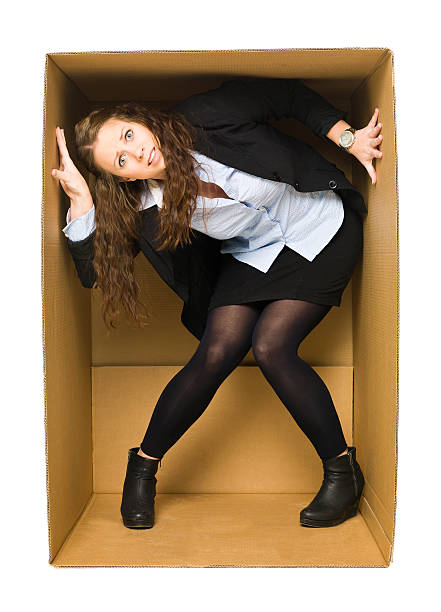 Businesswoman trapped in a cardboard box stock photo