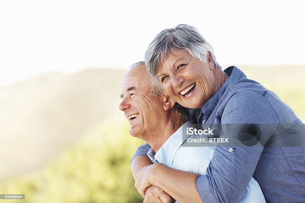Sorridente coppia abbracciare all'aperto - Foto stock royalty-free di 60-69 anni
