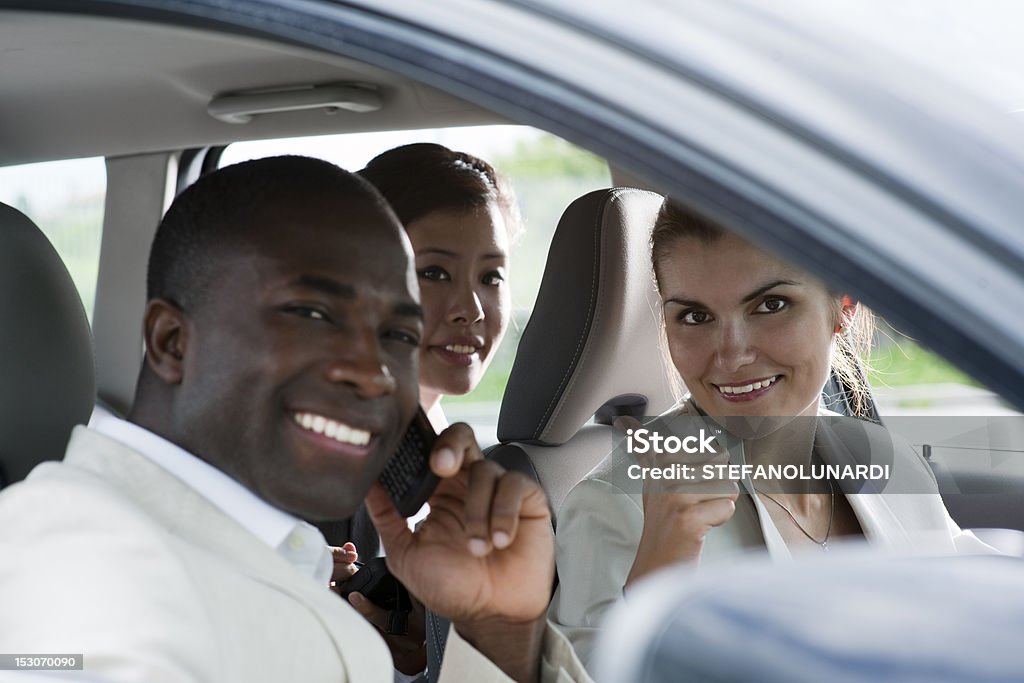 Car Pooling Multi-ethnic businesspeople sharing a car Car Pooling Stock Photo