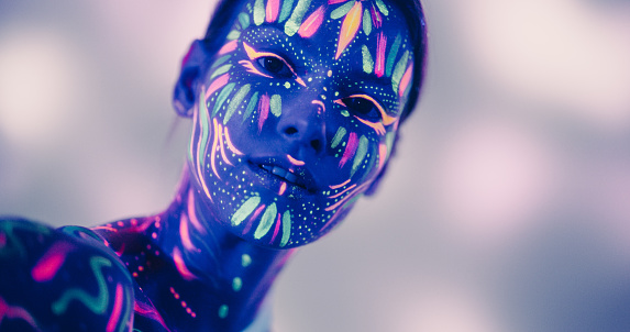 Innovative Beauty Advertising Shoot: Talented Model Showcases Her Unique Style, Neon-Painted Body and Face Contrasting Beautifully with Dark Abstract Backdrop, Creating a Visually Stunning Image