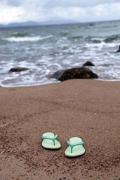 sandals sulla spiaggia - surfy foto e immagini stock