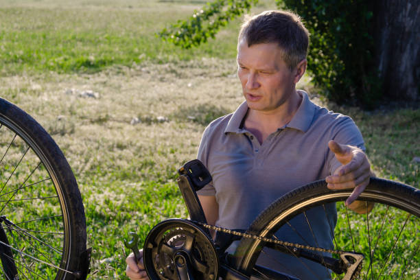 istock A man is repairing a bicycle on the lawn. 1530738575