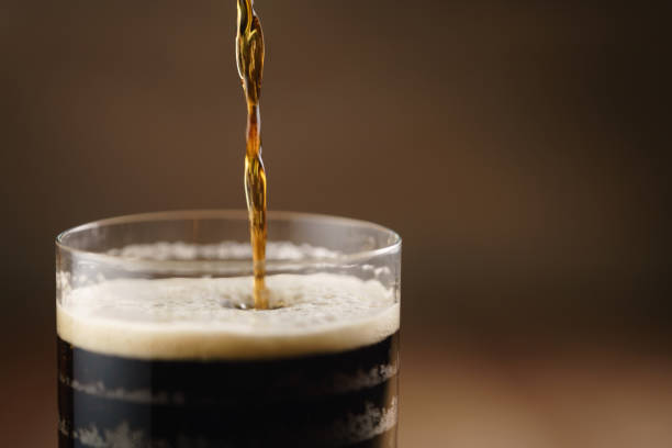 istock dark beer pouring in glass on wood table 1530758996