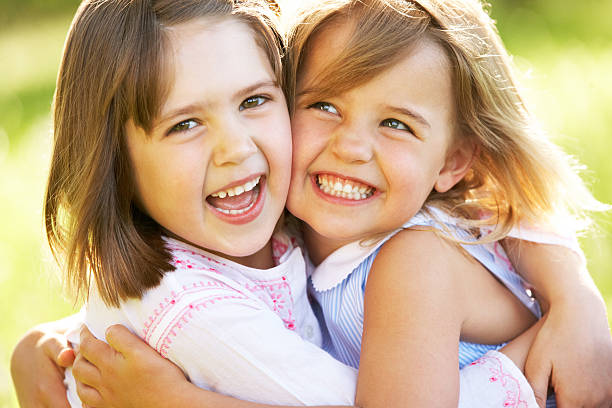 istock Two Young Girls Giving One Another Hug In Summer Field 153076310