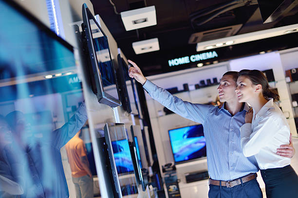 istock Man and woman browsing TVs together at an electronics store 153076578