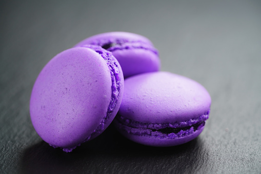 bright violet macarons on slate background, shallow focus