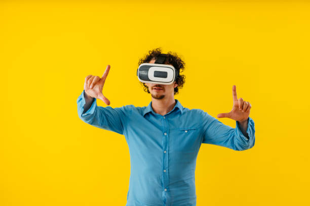 istock Young Man Playing A Virtual Reality Game In Front Of A Yellow Wall 1530776614