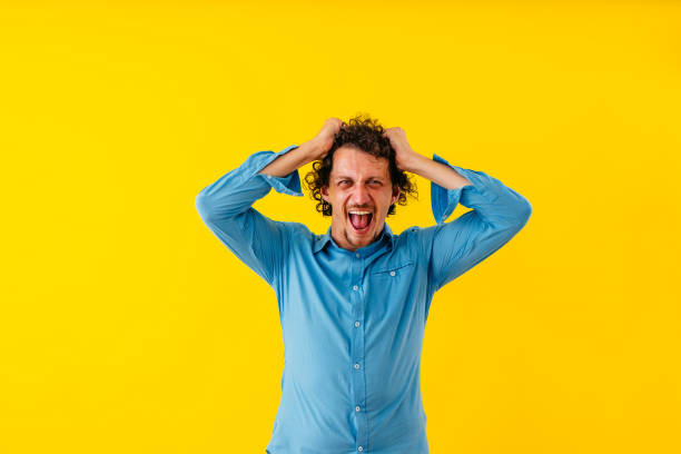 istock Angry Young Man Shouting While Standing In Front Of A Yellow Wall 1530778493