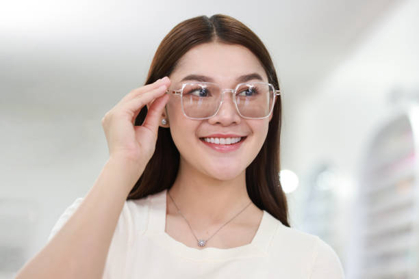 istock Beautiful young woman choosing eyeglasses frame in an optical store. 1530778807