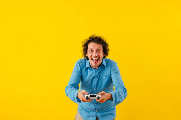 istock Happy Young Man Playing A Video Game In Front Of A Yellow Wall 1530778881