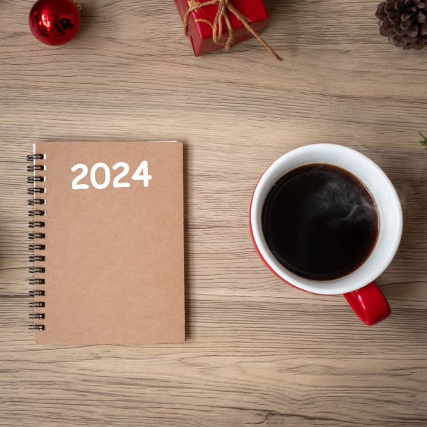 istock 2024 notebook, black coffee cup and Christmas gift on wood table, Top view and copy space. Xmas, Happy New Year, Goals, Resolution, To do list, Strategy and Plan concept 1530779202
