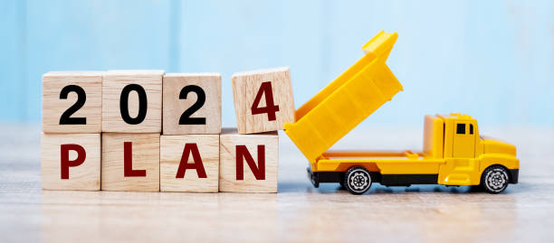 istock 2024 Plan cube blocks with miniature truck or construction vehicle. New Start, Vision, Resolution, goal, industrial, Warehouse and happy New Year concept 1530779344