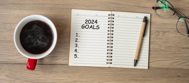 istock 2024 GOAL with notebook, black coffee cup and pen on wood table, Top view and copy space. Happy New Year, Resolution, To do list, Strategy and Plan concept 1530779993
